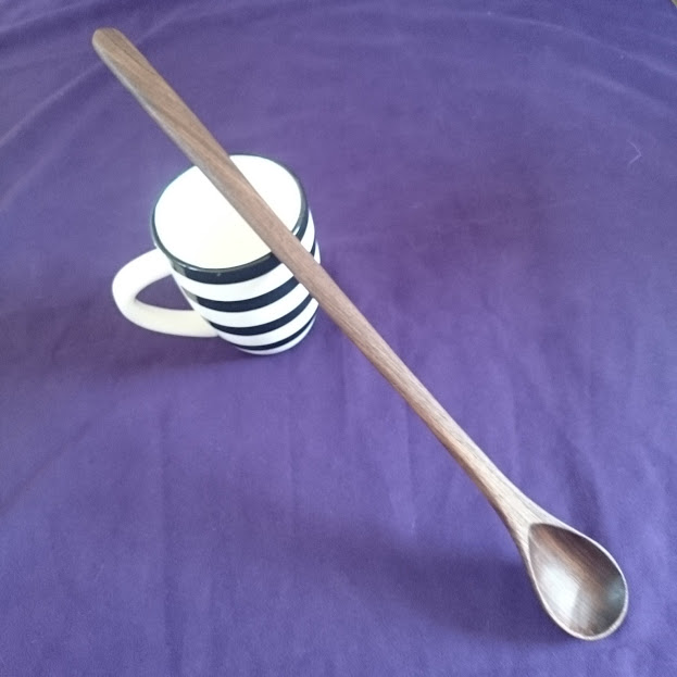 An extra long handcarved wooden spoon in black walnut wood